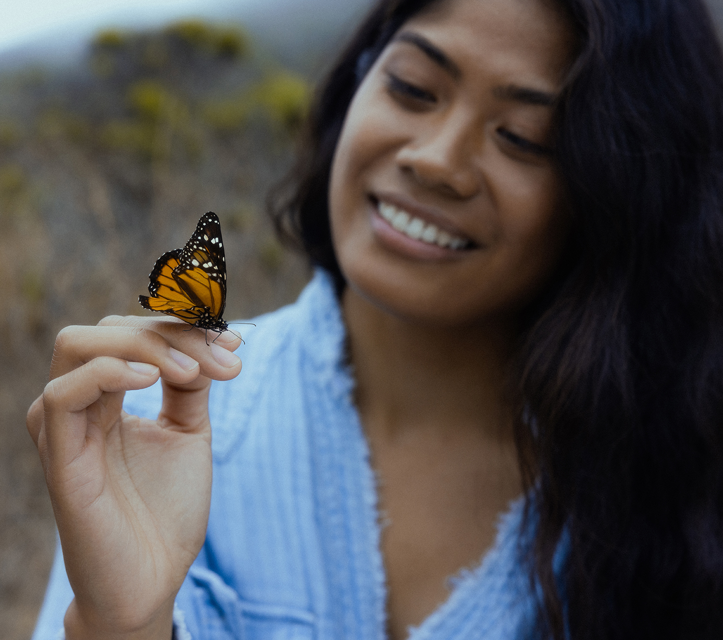 Woman holding a monarch butterfly