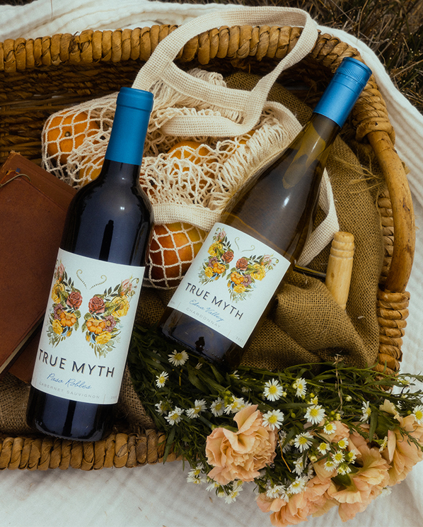 True Myth Paso Robles Cabernet Sauvignon and True Myth Edna Valley Chardonnay in a picnic basket with flowers and fruit